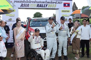 Takuma Aoki (balra középen) és a másodpilóták, Ittipon Simaraks (középen) és Songwut Danphiphattrankoon (jobbra középen), karjukat emelik a Toyota Fortuner terepjáró (#105) előtt, miután megnyerték az összesített bajnokságot