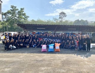 A commemorative photo of the natural rubber farmers behind the fertilizer they received